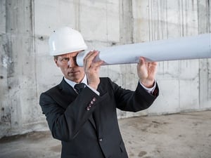 A man wearing a white helmet and a suit