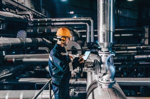 A man looking at tablet in a factory