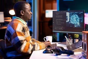 A professional working on a computer showing an AI-generated brain graphic, illustrating Pinja's expertise in AI and Microsoft 365 solutions