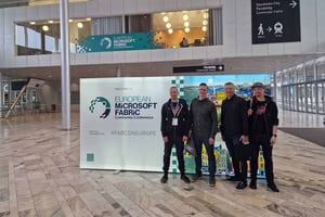 Fyra dataspecialister från Pinja står bredvid en stor välkomstskylt för European Microsoft Fabric Community Conference i en modern eventhall i Stockholm.